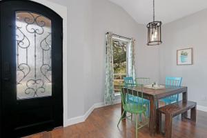 a dining room with a table and chairs and a black door at Comal Cottage in Canyon Lake