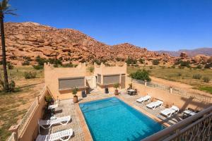 a house with a swimming pool in front of a mountain at Dar izem in Tafraout