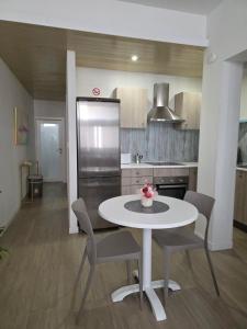 a kitchen with a table and chairs and a refrigerator at Aurora in Marsaskala