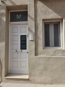 a white door on a building with a window at Aurora in Marsaskala
