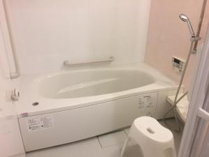 a white bath tub in a bathroom with a toilet at The Familiar Inn ー 2 min walk to subway, 5 min to Namba Station in Osaka +37 photos
