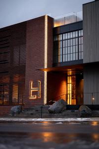 a brick building with a lit up sign on it at Larch House in Whitefish