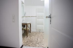 a bathroom with a white door and a table at Altstadtloft am Kaulberg in Bamberg
