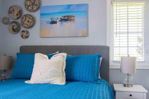 a blue bed with blue pillows in a bedroom at Apartment in Prince Edward County - 'Suite Spot' in Picton
