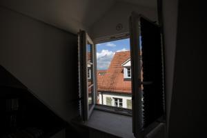 an open window with a view of a house at Altstadtloft am Kaulberg in Bamberg