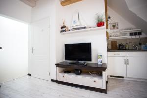 a living room with a flat screen tv on a cabinet at Altstadtloft am Kaulberg in Bamberg +8 photos