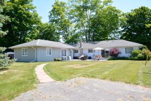 a white house with a lawn in front of it at Apartment in Prince Edward County - 'Suite Spot' in Picton