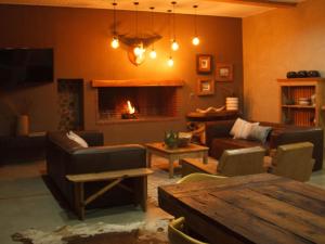 a living room with a couch and a fireplace at Stroomrivier Lodge in Boshoek