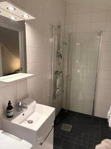 a white bathroom with a sink and a shower at Cozy apartment in Kungsbacka