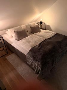 a large bed with white sheets and pillows in a bedroom at Cozy apartment in Kungsbacka