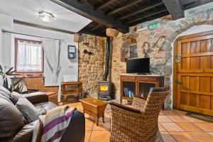 a living room with a couch and a fireplace at Casa Rural Moradiellos-Cabrales Axtur 4 personas con vistas in Arenas de Cabrales +19 photos