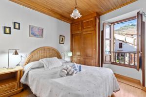 a bedroom with a large bed and a window at Casa Rural Moradiellos-Cabrales Axtur 4 personas con vistas in Arenas de Cabrales