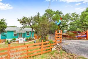 a chicken statue on a fence in front of a house at Coop at Canyon Lake in Canyon Lake