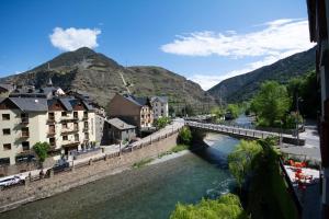 a bridge over a river in a town with mountains at La Noguera de Llavorsí in Llavorsí