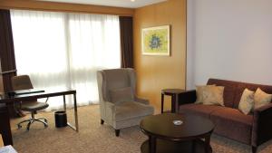 uma sala de estar com um sofá, uma mesa e um piano em Holiday Inn Shijiazhuang Central, an IHG Hotel em Shijiazhuang