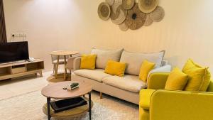 a living room with a couch and yellow pillows at نوليتا للشقق الفندقية in Abha