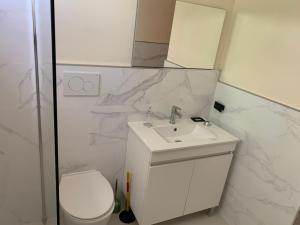 a white bathroom with a sink and a toilet at Condominio cortico in Mendoza +1 photo