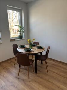 a dining room with a table and chairs and a window at Apartament Przy Parku in Bełchatów