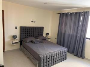 a bedroom with a large bed with a large headboard at Condominio cortico in Mendoza