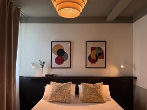 a bedroom with a bed and three paintings on the wall at Foresteria 33 in Ghedi