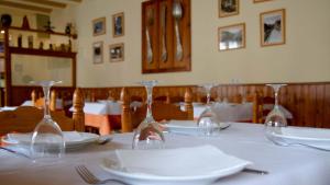 a table with wine glasses on a white table cloth at La Noguera de Llavorsí in Llavorsí