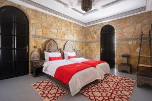a bedroom with a large bed with a red blanket at Dar izem in Tafraout +75 photos