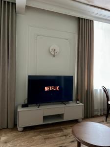 a living room with a television on a white entertainment center at K2 Apartment in Tarnów