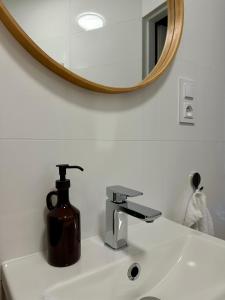a bathroom sink with a soap dispenser and a mirror at K2 Apartment in Tarnów +31 photos