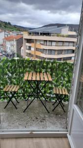 a picnic table on a balcony with a view of a building at Charmant T2 Spacieux idéalement situé - 2 chambres in Clermont-Ferrand