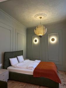a bedroom with a large bed with a chandelier at K2 Apartment in Tarnów
