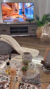a living room with a tv and a glass table at Deem view in Al Ain