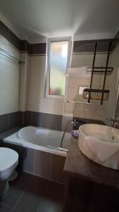 a bathroom with a tub and a toilet and a sink at Nàra house in Áyios Spirídhon +10 photos