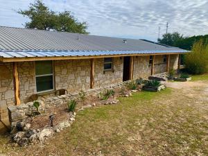 a stone house with a yard in front of it at La Vista in Canyon Lake
