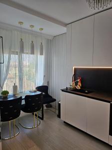 a kitchen with a table and a dining room at Luxury Promenada Craiova in Craiova