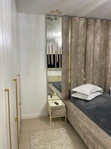 a bedroom with a large bed and a mirror at Luxury Promenada Craiova in Craiova