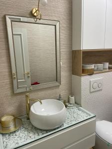 a bathroom with a white sink and a mirror at Luxury Promenada Craiova in Craiova