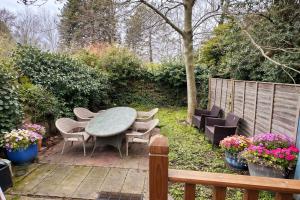 a patio with a table and chairs and flowers at HollyTree - Family and Business Stay with parking in Cambridge