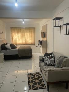 a living room with a bed and a couch at Apartamento com piscina in Ponta Grossa