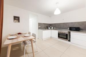 a kitchen with a wooden table and a kitchen with white cabinets at Les Remparts du Loing in Moret-sur-Loing