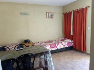 a bedroom with a bed and a table with chairs at Complejo San Eduardo, Chapadmalal in Colonia Chapadmalal +13 photos