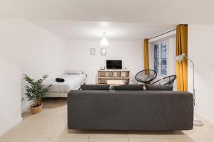 a living room with a couch and a bed at Les Remparts du Loing in Moret-sur-Loing