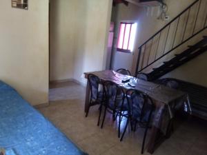 a table and chairs in a room with a staircase at Complejo San Eduardo, Chapadmalal in Colonia Chapadmalal