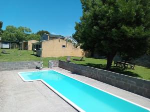 a swimming pool in a yard with a tree at Complejo San Eduardo, Chapadmalal in Colonia Chapadmalal