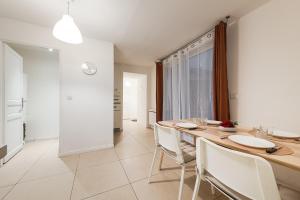 a kitchen and dining room with a wooden table and chairs at Les Remparts du Loing in Moret-sur-Loing +19 photos