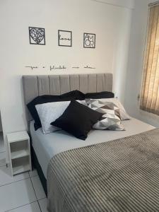 a bedroom with a large bed with pillows on it at Apartamento com piscina in Ponta Grossa +19 photos