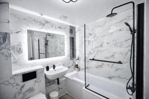 a white bathroom with a sink and a shower at HollyTree - Family and Business Stay with parking in Cambridge +15 photos