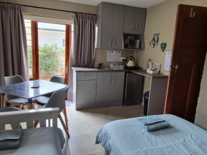 a room with a kitchen and a table and a table and a bed at 5Viooltjie in Riversdale