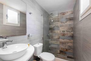a bathroom with a sink and a toilet and a mirror at Santa Irini 1 in Vourvoúlos
