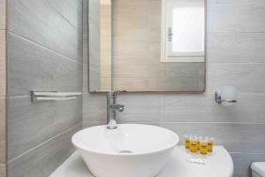 a bathroom with a white sink and a mirror at Santa Irini 1 in Vourvoúlos