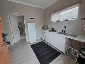 a kitchen with a sink and a white refrigerator at Munnik Rest in Polokwane